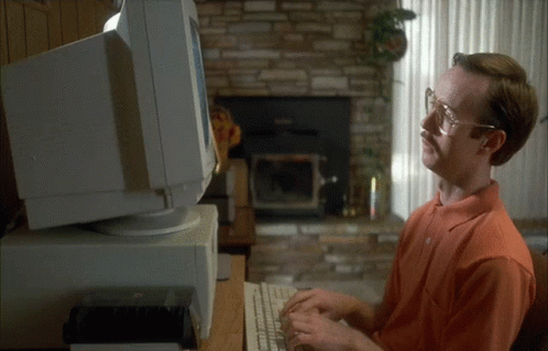A Man With Glasses And A Mustache Is Typing On A Keyboard In Front Of A Computer Monitor GIF