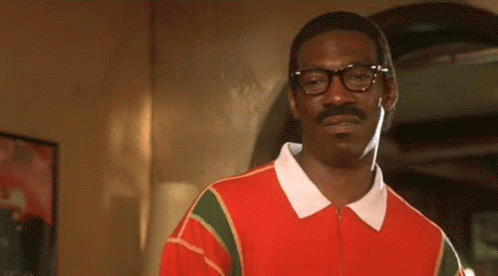 A Man With Glasses And A Mustache Is Wearing A Red Shirt And A White Collar . GIF