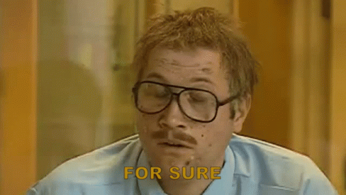 A Man With Glasses And A Mustache Says `` For Sure '' While Smoking A Cigarette . GIF