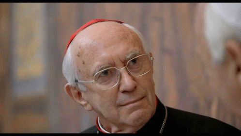 A Man With Glasses And A Red Hat Looks To The Side GIF