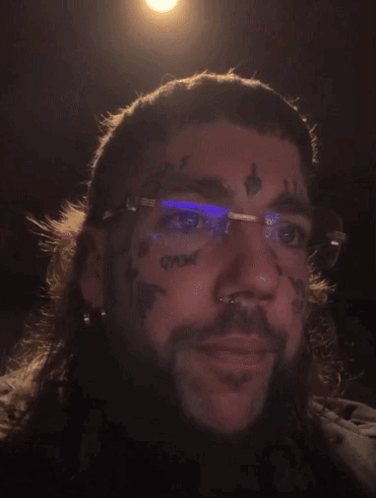 A Man With Glasses And A Tattoo On His Face GIF