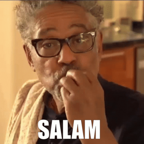 A Man With Glasses And A Towel Around His Neck Is Eating Something And The Word Salam Is Above Him GIF