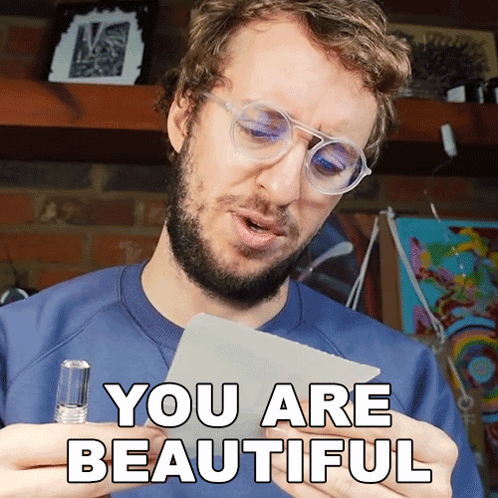 A Man With Glasses Holds A Piece Of Paper That Says " You Are Beautiful " GIF