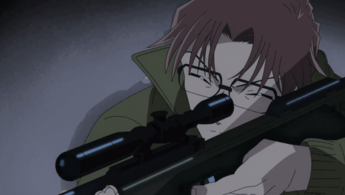 A Man With Glasses Holds A Sniper Rifle In His Hand GIF