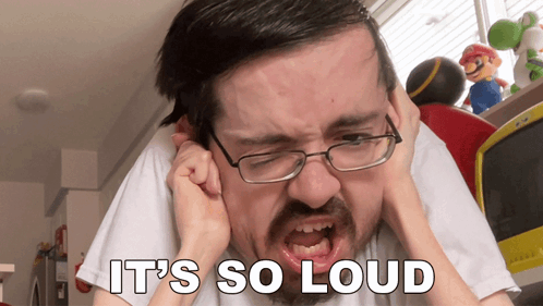 A Man With Glasses Is Covering His Ears And The Words It 'S So Loud Are Above Him GIF