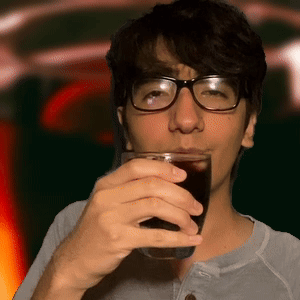 A Man With Glasses Is Drinking A Glass Of Soda GIF