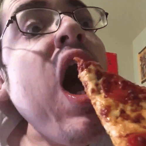 A Man With Glasses Is Eating A Slice Of Pepperoni Pizza GIF