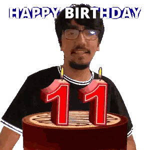 a man with glasses is holding a cake with candles in the shape of the number 11