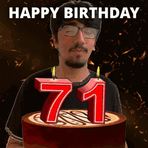 A Man With Glasses Is Holding A Cake With Candles In The Shape Of The Number 71 GIF