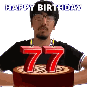 a man with glasses is holding a cake with candles in the shape of the number 77