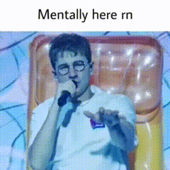 A Man With Glasses Is Holding A Microphone And Says Mentally Here Rn . GIF