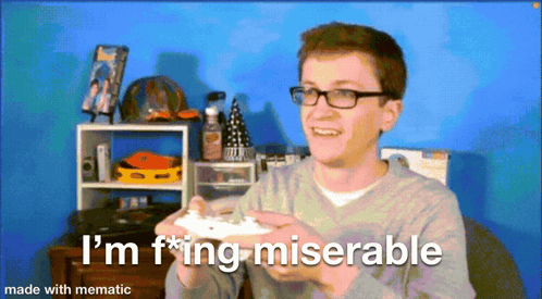A Man With Glasses Is Holding A Video Game Controller And Says I 'M F * Ing Miserable Made With Mematic GIF