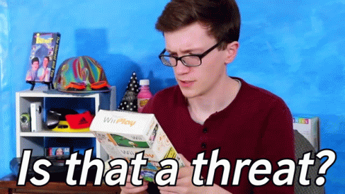 A Man With Glasses Is Holding A Wii Play Game In His Hand GIF