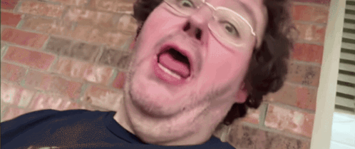 A Man With Glasses Is Making A Funny Face GIF
