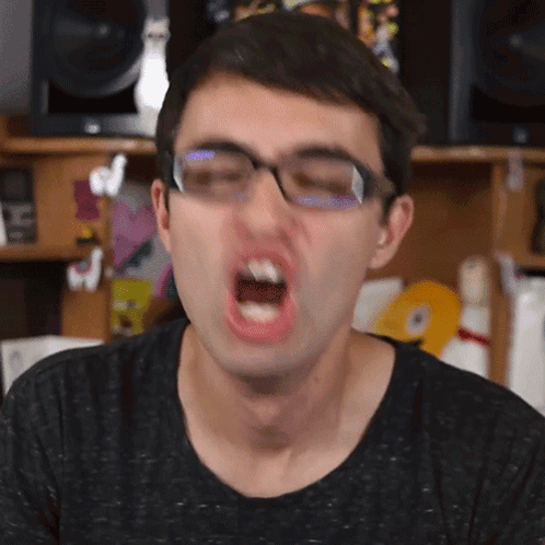 A Man With Glasses Is Making A Funny Face GIF