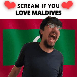 A Man With Glasses Is Screaming In Front Of A Flag That Says Scream If You Love Maldives GIF