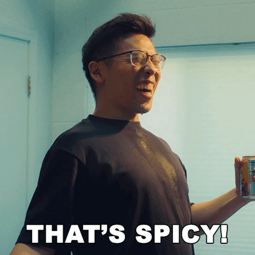 A Man With Glasses Is Smiling And Holding A Can Of Soda With The Words That 'S Spicy Below Him GIF
