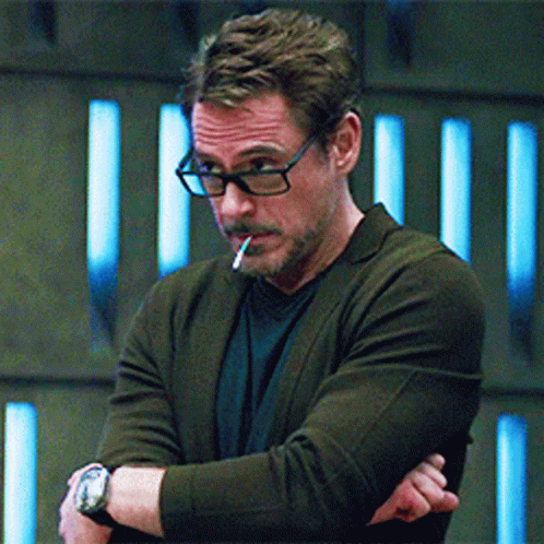 A Man With Glasses Is Smoking A Cigarette GIF