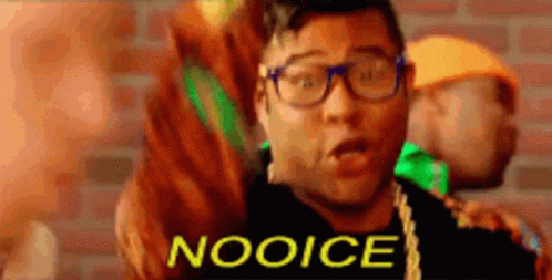 A Man With Glasses Is Standing In Front Of A Brick Wall And Says Nooice GIF