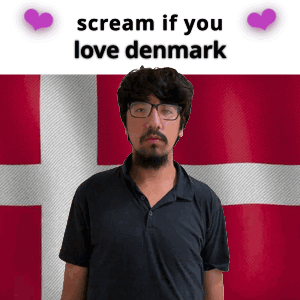 A Man With Glasses Is Standing In Front Of A Denmark Flag GIF