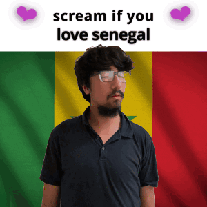 a man with glasses is standing in front of a senegal flag