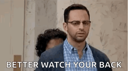 A Man With Glasses Is Standing Next To Another Man With A Beard And Says `` Better Watch Your Back '' . GIF