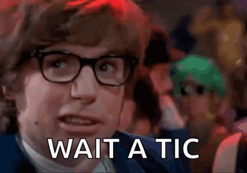 A Man With Glasses Says Wait A Tic In Front Of A Crowd . GIF
