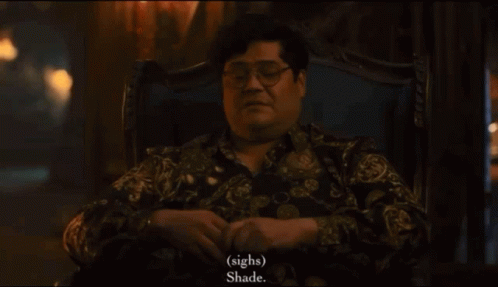 A Man With Glasses Sits In A Chair And Says " Sighs " And " Shade " GIF