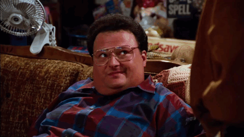 A Man With Glasses Sits On A Couch With The Words I Need A Really Pretty Face Above Him GIF