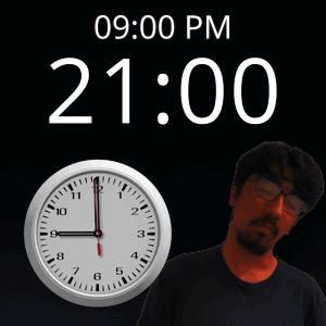 A Man With Glasses Stands In Front Of A Clock That Reads 21:00 GIF
