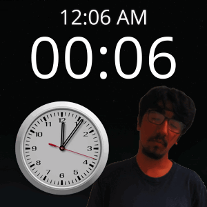 A Man With Glasses Stands In Front Of A Clock That Says 12:06 Am GIF