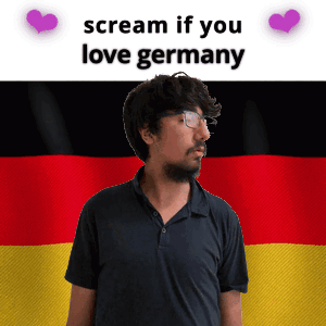 A Man With Glasses Stands In Front Of A German Flag With The Words Scream If You Love Germany GIF