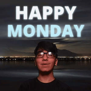 A Man With Glasses Stands In Front Of A Happy Monday Sign GIF