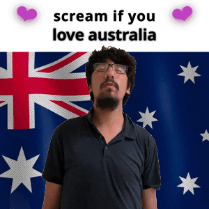 A Man With Glasses Stands In Front Of An Australian Flag GIF