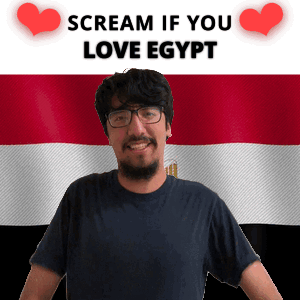 A Man With Glasses Stands In Front Of An Egyptian Flag And A Sign That Says Scream If You Love Egypt GIF