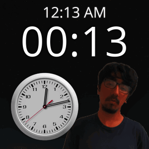 A Man With Glasses Stands Next To A Clock That Says 12:13 Am GIF