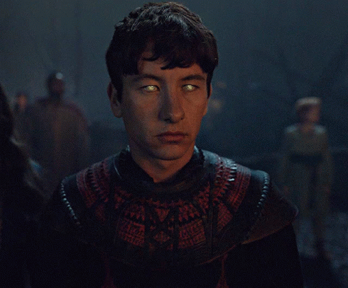 A Man With Glowing Green Eyes Is Wearing A Black And Red Sweater GIF