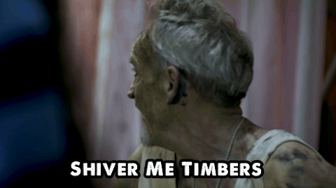 A Man With Gray Hair And A White Tank Top Says Shiver Me Timbers GIF