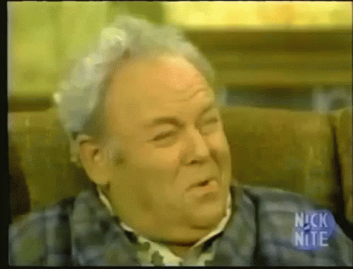 Gray Hair Man Sitting With Nick Nite Sign GIF