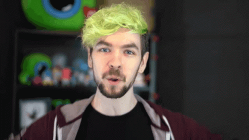 A Man With Green Hair And A Beard Is Wearing A Black Shirt GIF