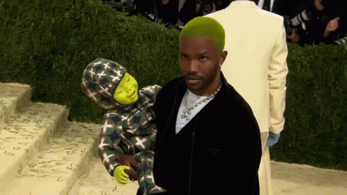 A Man With Green Hair Is Holding A Child With Shrek On It GIF