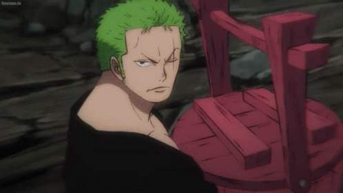 A Man With Green Hair Is Standing Next To A Red Chair That Says Bokuma.tv GIF