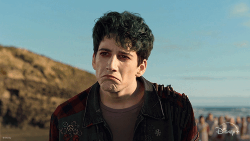 A Man With Green Hair Is Wearing A Plaid Shirt And A Disney + Jacket GIF