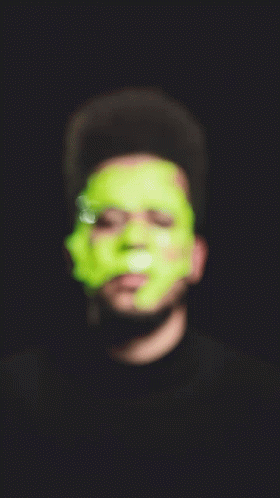 A Man With Green Tape On His Face Looking At The Camera GIF