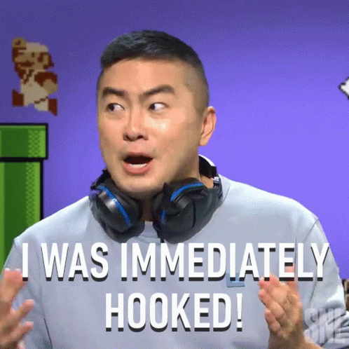 A Man With Headphones Around His Neck Says " I Was Immediately Hooked " GIF