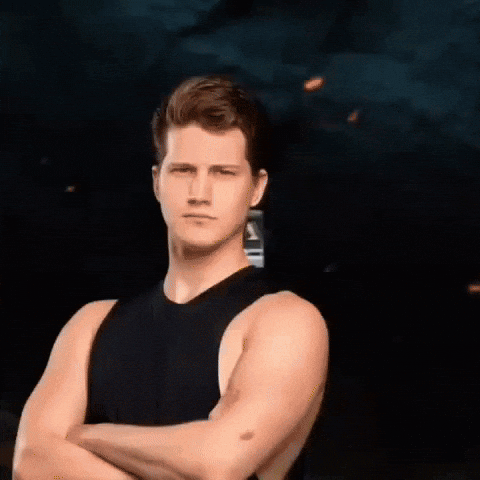 A Man With His Arms Crossed In Front Of A Bus GIF