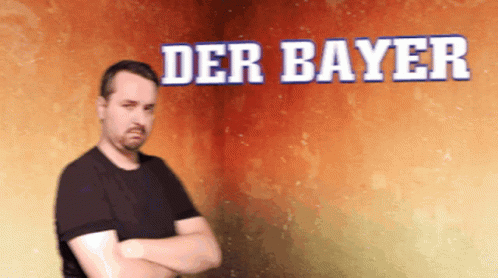 A Man With His Arms Crossed Is Standing In Front Of A Wall That Says Der Bayer GIF