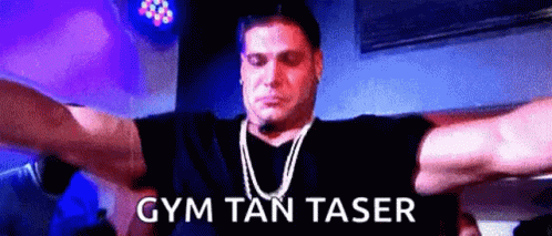 A Man With His Arms Outstretched And The Words Gym Tan Taser On The Bottom Right GIF