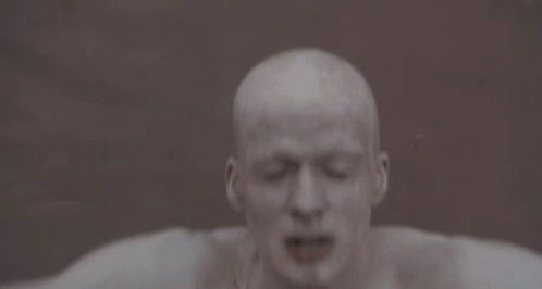A Man With His Arms Outstretched Has A Tattoo On His Chest That Says ' I ' GIF