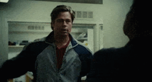 A Man With His Arms Outstretched Is Talking To A Woman In A Kitchen . GIF